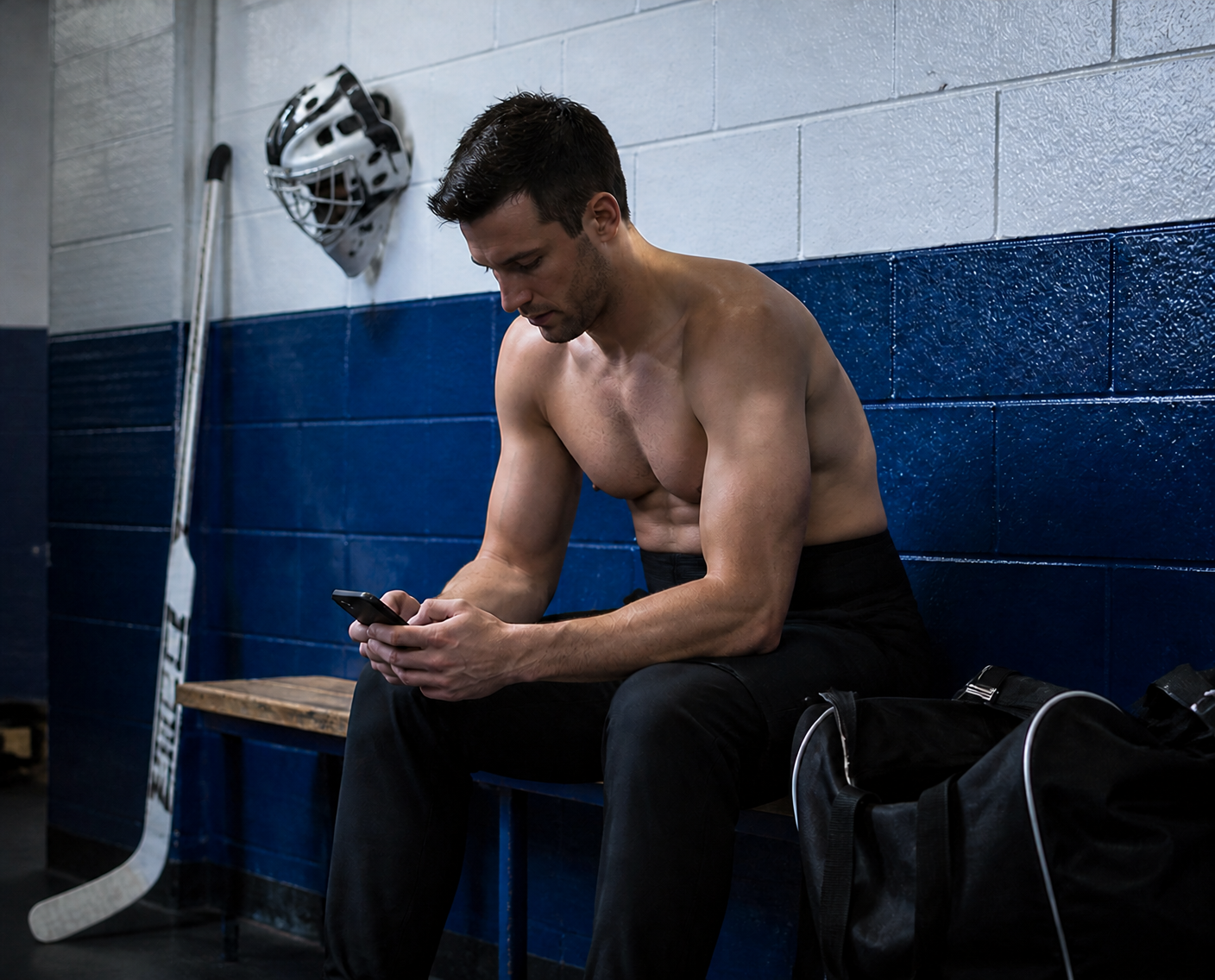 Hockey player sitting in a locker room, focused on his phone